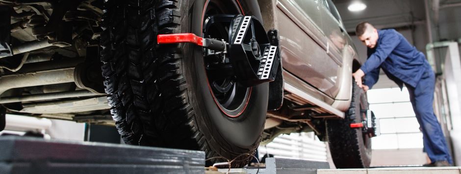 mechanic checking front and back wheel for alignment